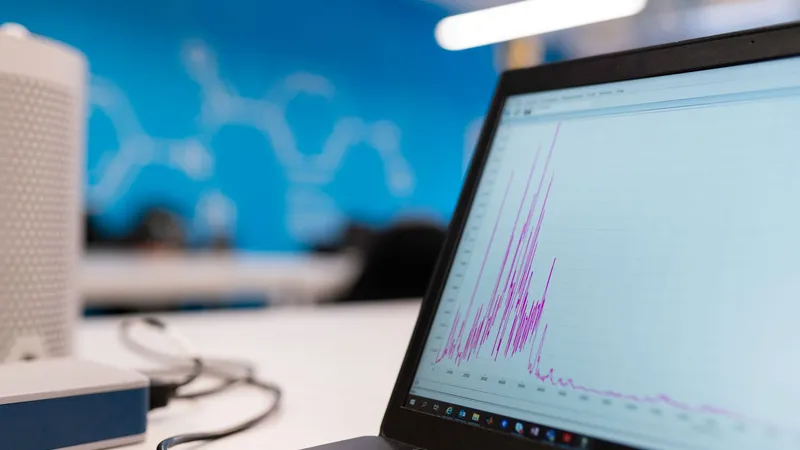 Analista visualizando gráficos de tráfego em laptop, representando picos de acesso e escalabilidade